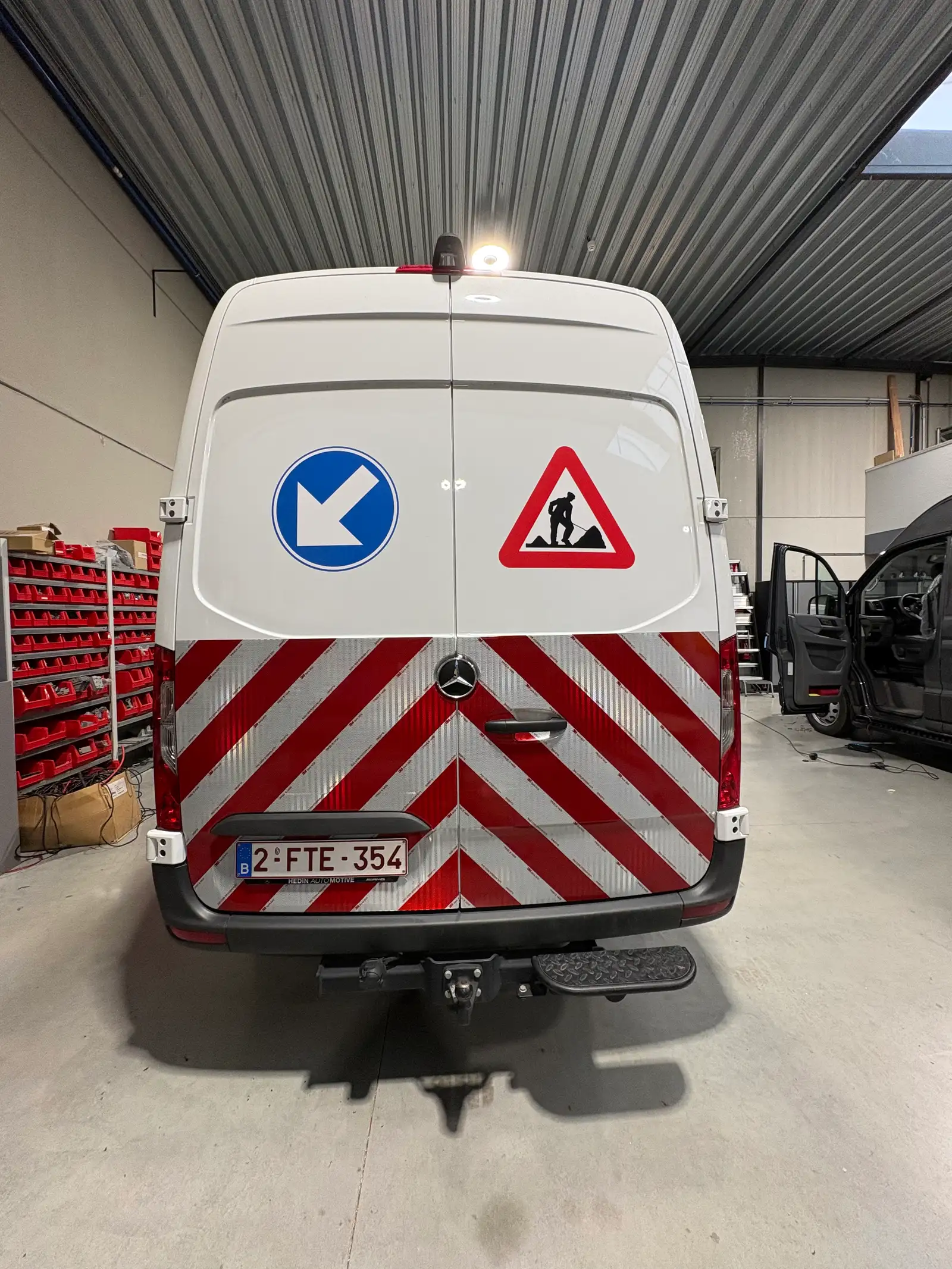 Werfvoertuig met chevronmarkering en verkeersbord-stickers op de achterdeuren