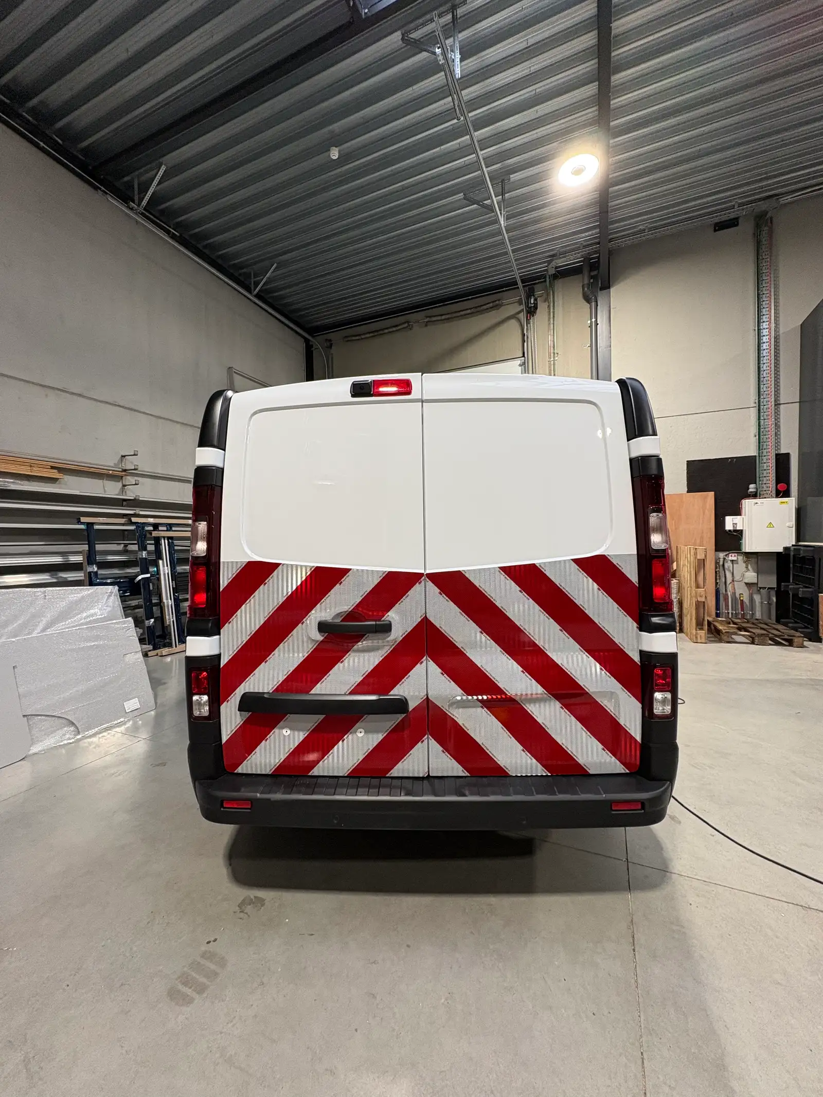 Achterkant van een bestelwagen met rood-witte chevronmarkering onderaan