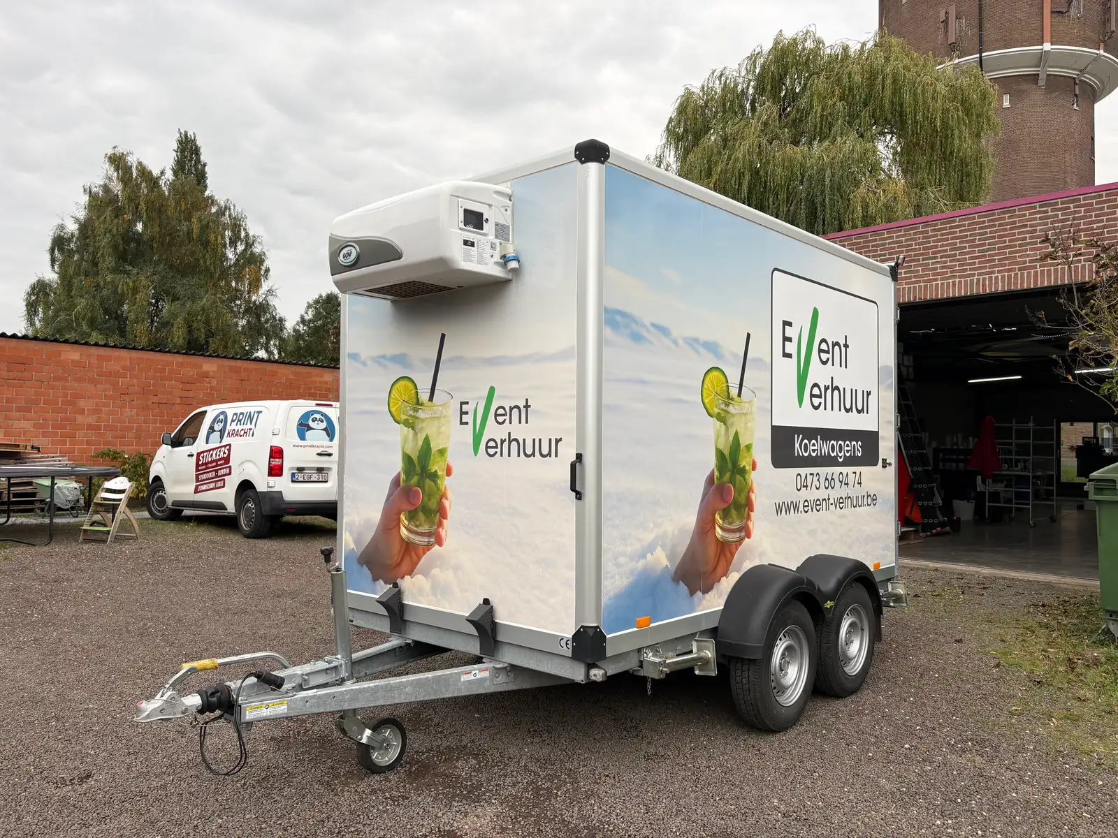 Zijkant van een beletterde verhuur-aanhangwagen met kleurrijk ontwerp