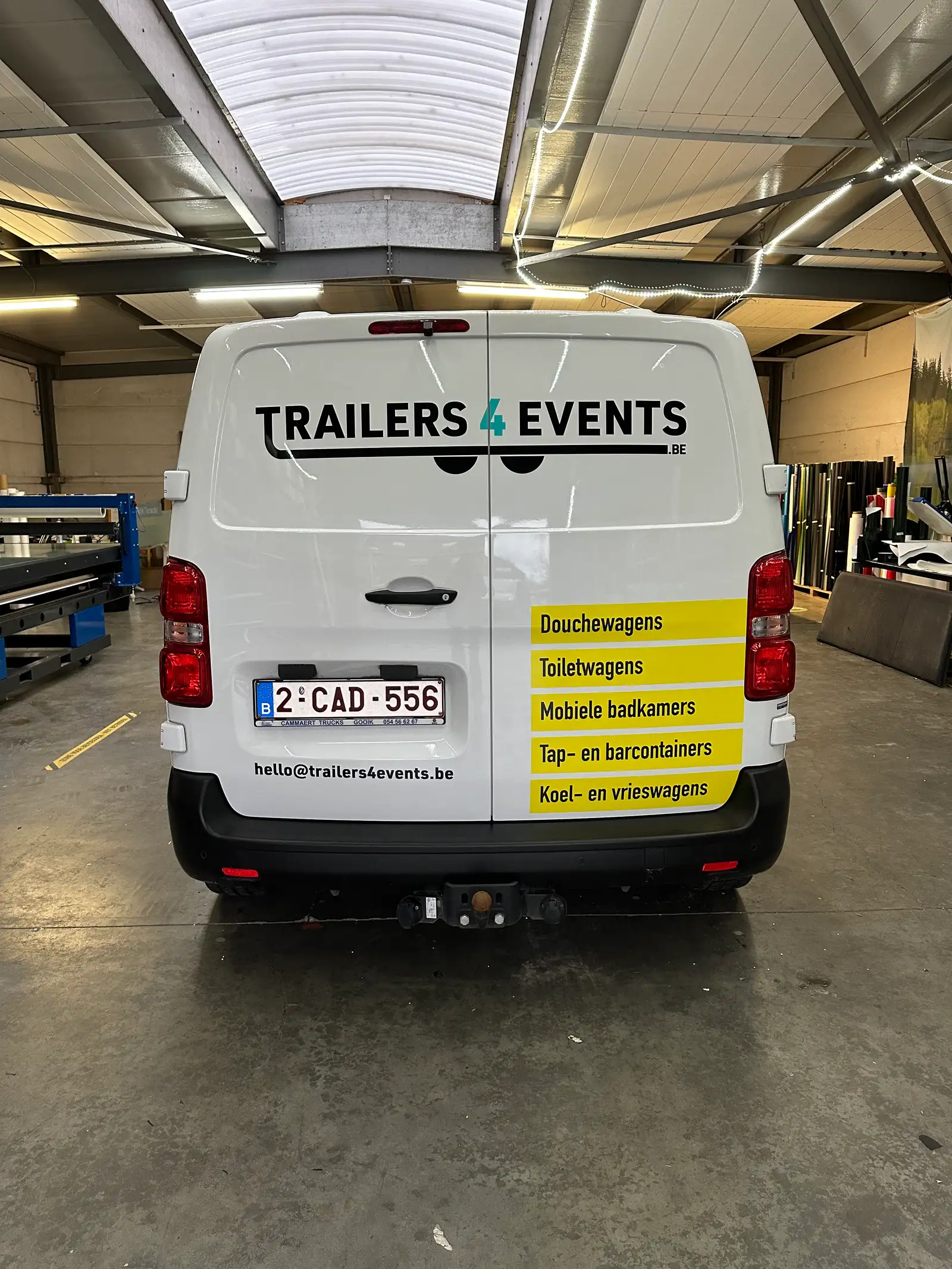Achterkant van een verhuur-camionette met kleurrijke printstickers