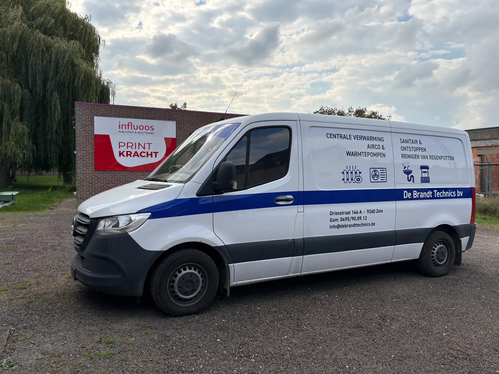 Camionette van een loodgieter met strakke logobelettering op de zijkant