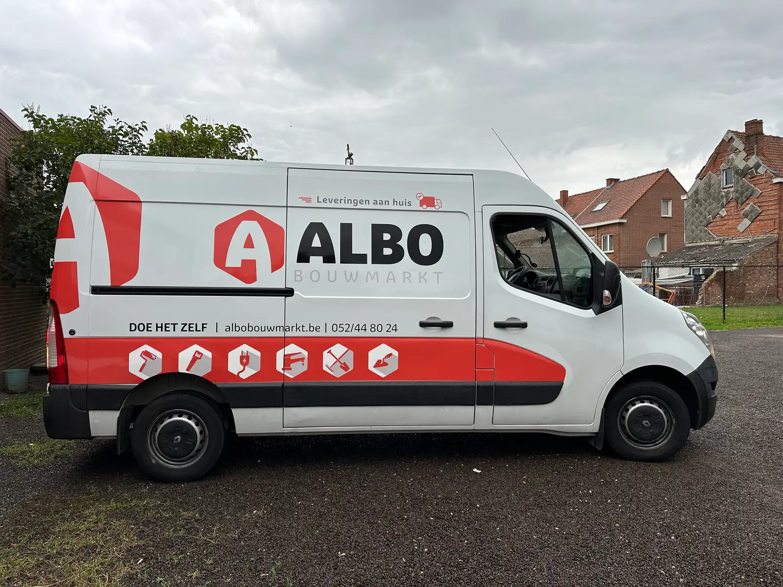 Bestelwagen met rood-witte huisstijlbelettering over de volledige zijkant