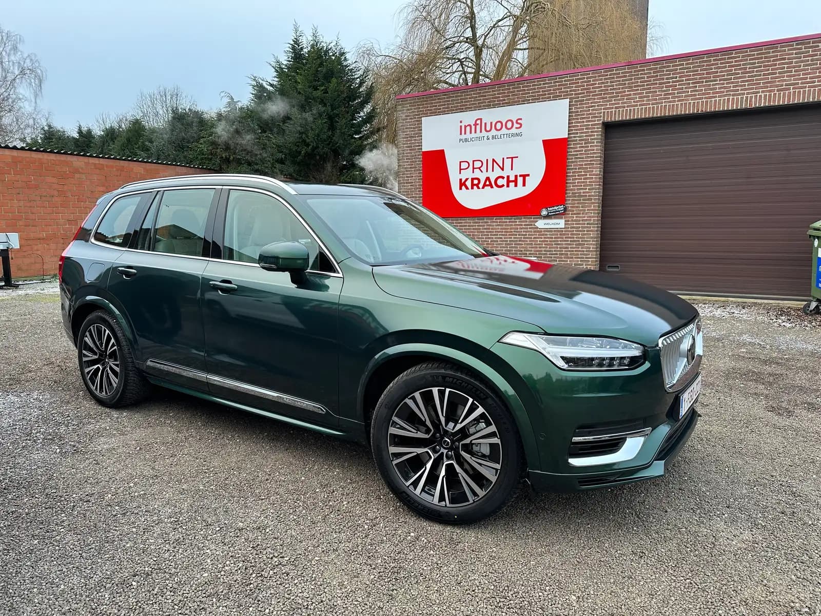 SUV in blinkend metallic groen na een full carwrap, zijaanzicht buiten het atelier in Lokeren
